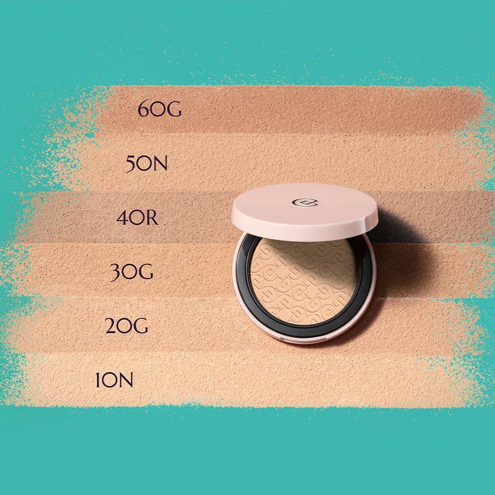 Une boîte de poudre compacte ouverte à côté de six échantillons de couleur, du beige clair au foncé.