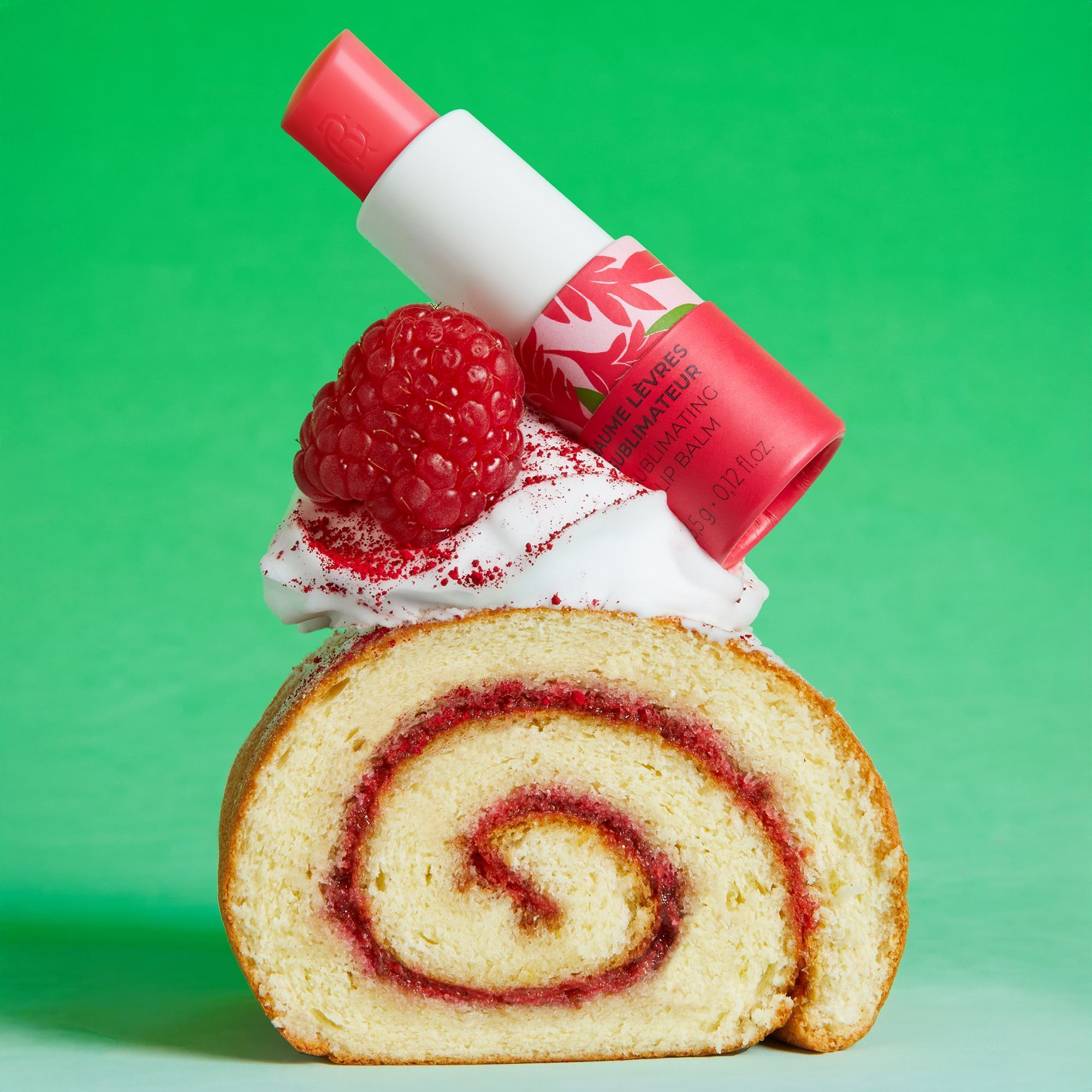Un baume à lèvres Roger&Gallet sur une part de roulé à la framboise et à la crème.