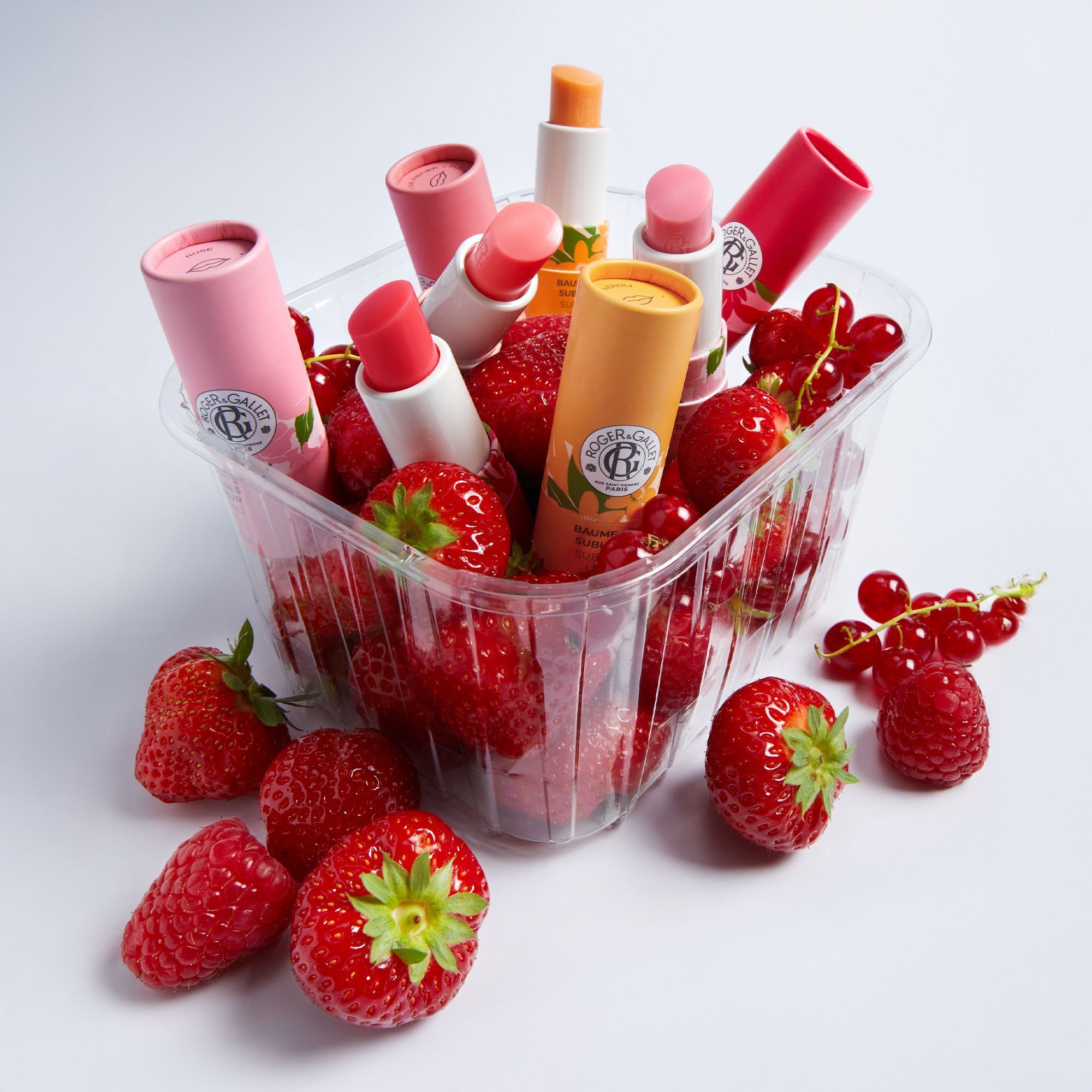 Baumes à lèvres Roger&Gallet dans une barquette avec fraises, framboises et groseilles.