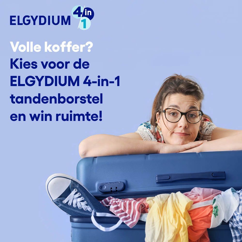 Een vrouw ligt op een blauwe koffer, gevuld met kleding.