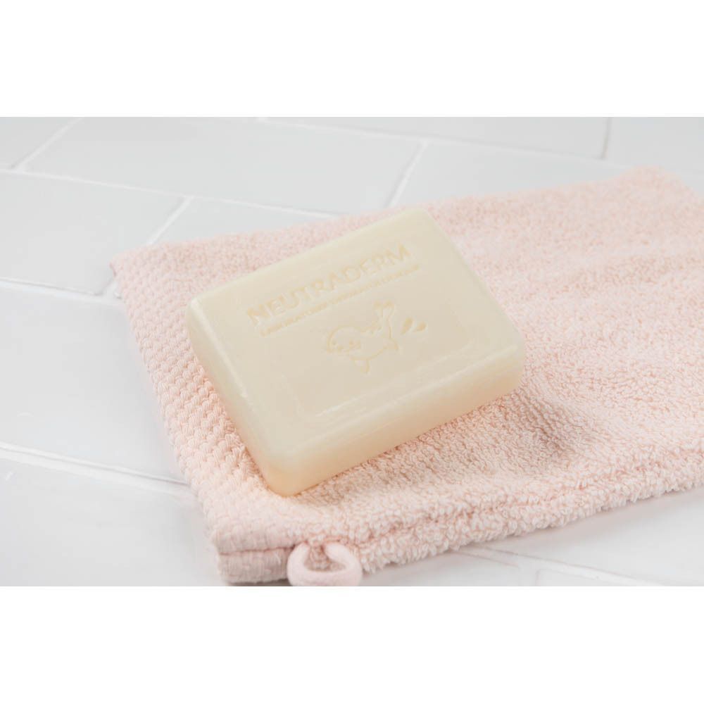 Een stuk Neutroderm Baby Savon Surgras Douceur 3-in-1 zeep op een roze handdoek.
