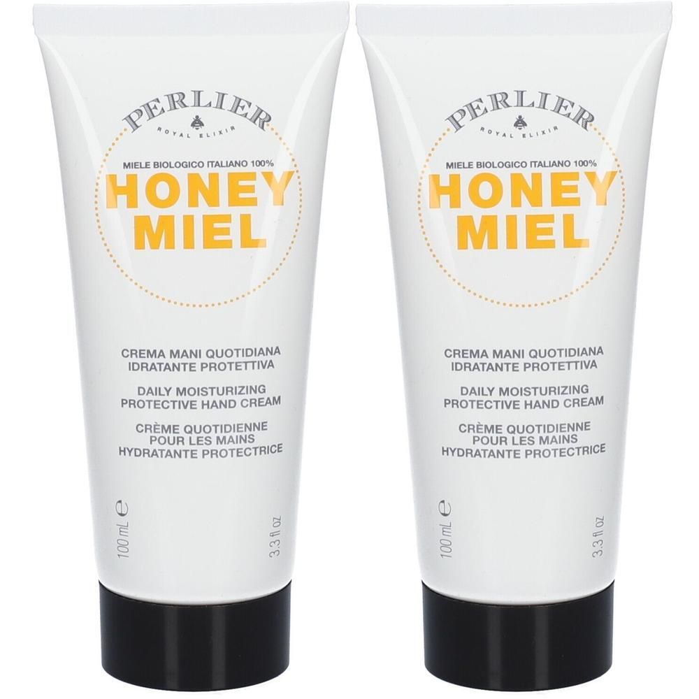 Deux tubes blancs de crème pour les mains avec bouchon noir. "HONEY MIEL" en lettres jaunes.