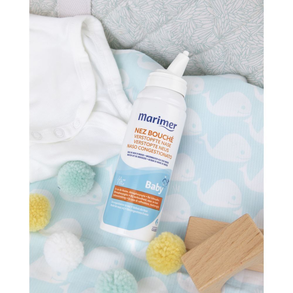Marimer Baby neusspray op babykleding met speelgoed.