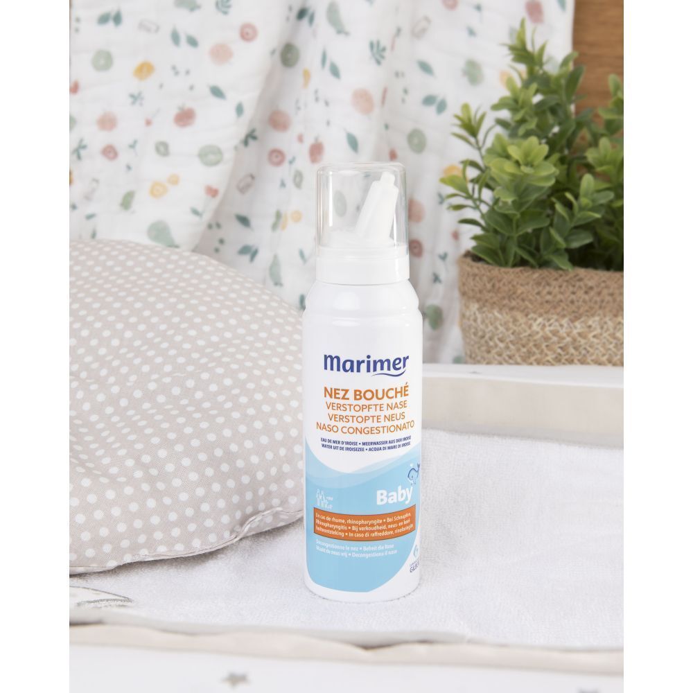 Marimer Baby neussprayfles op een nachtkastje met plant.