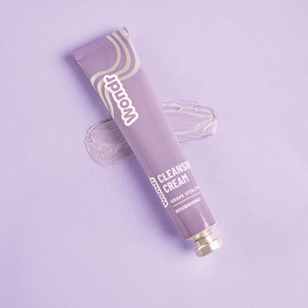Tube violet WONDR Cleansing Cream Grape Vitality avec une touche de crème à côté.