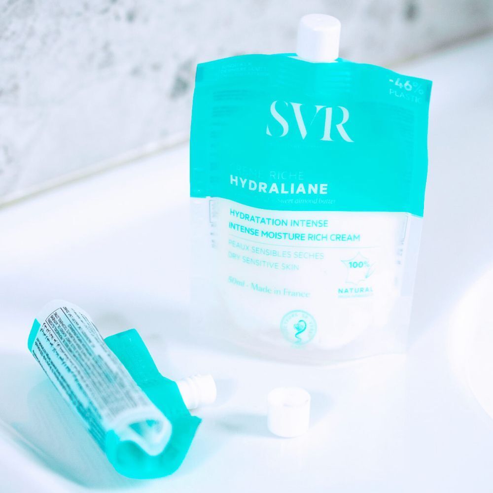 Une pochette ouverte de SVR Hydraliane Crème Riche hydratante, bouchon à côté.