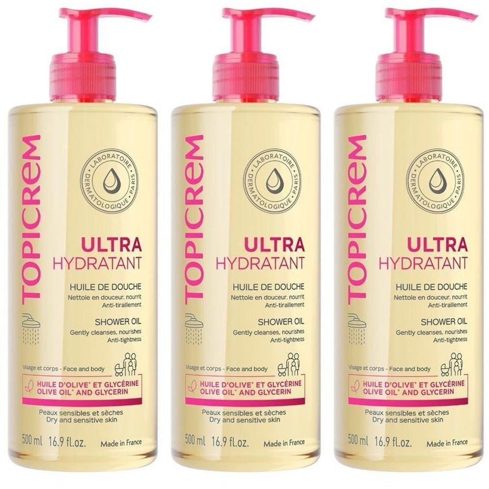 Trois flacons d'Huile de Douche Topicrem Ultra Hydratant avec pompes. Liquide clair dans des bouteilles transparentes avec étiquettes roses et blanches.