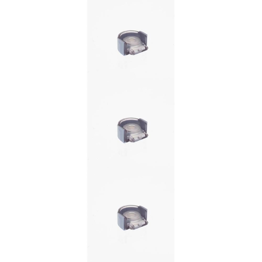 Trois petites pièces grises en plastique avec des inserts transparents, disposées verticalement.