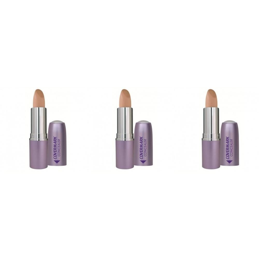 Trois bâtons de correcteur de couleur chair claire avec capuchon violet et manche argenté.