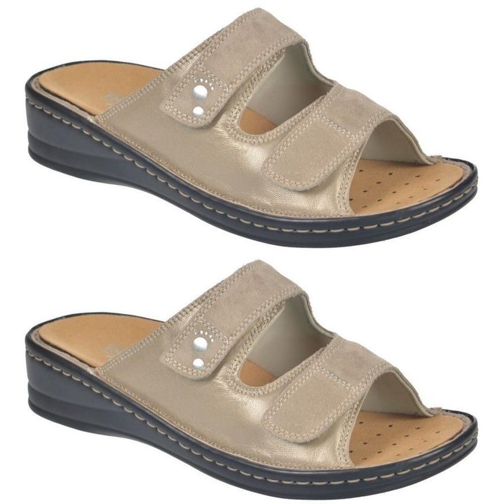 Deux sandales dorées pour femmes avec fermeture velcro et talon compensé.