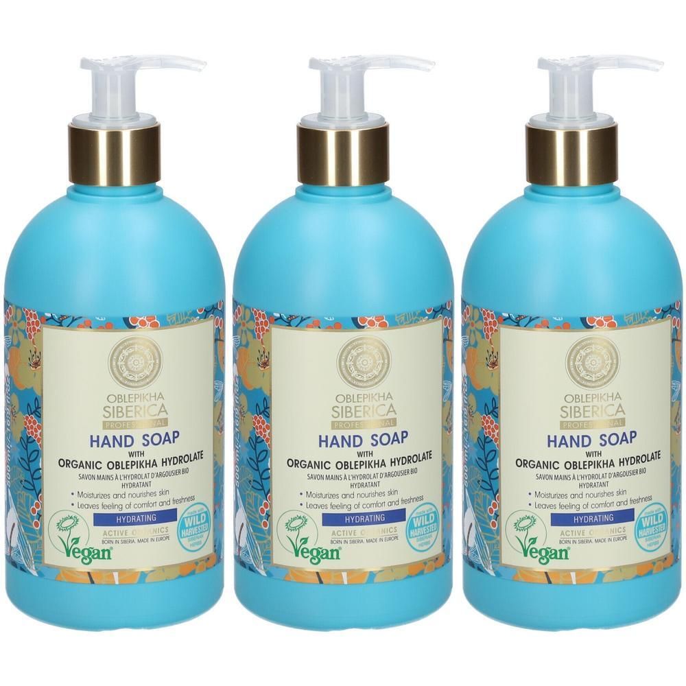 Drie blauwe handzeepdispensers met gouden pompen en bloemenetiket.