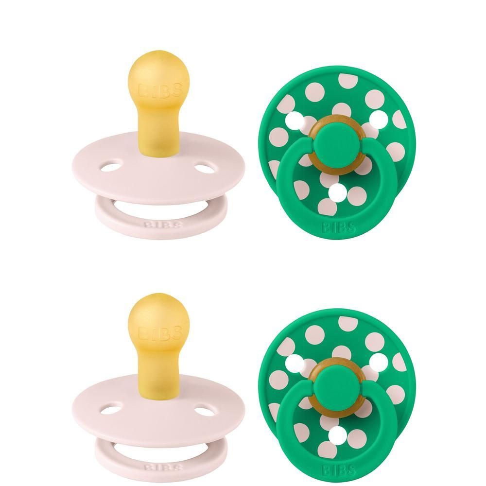 Deux sucettes BIBS : une rose à tétine jaune et une verte à pois blancs à tétine jaune.