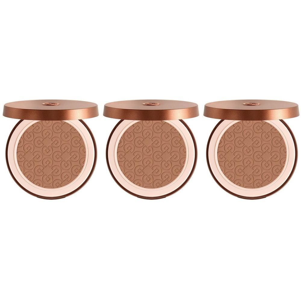 Drie bronzing poeders in ronde doosjes met open deksels.