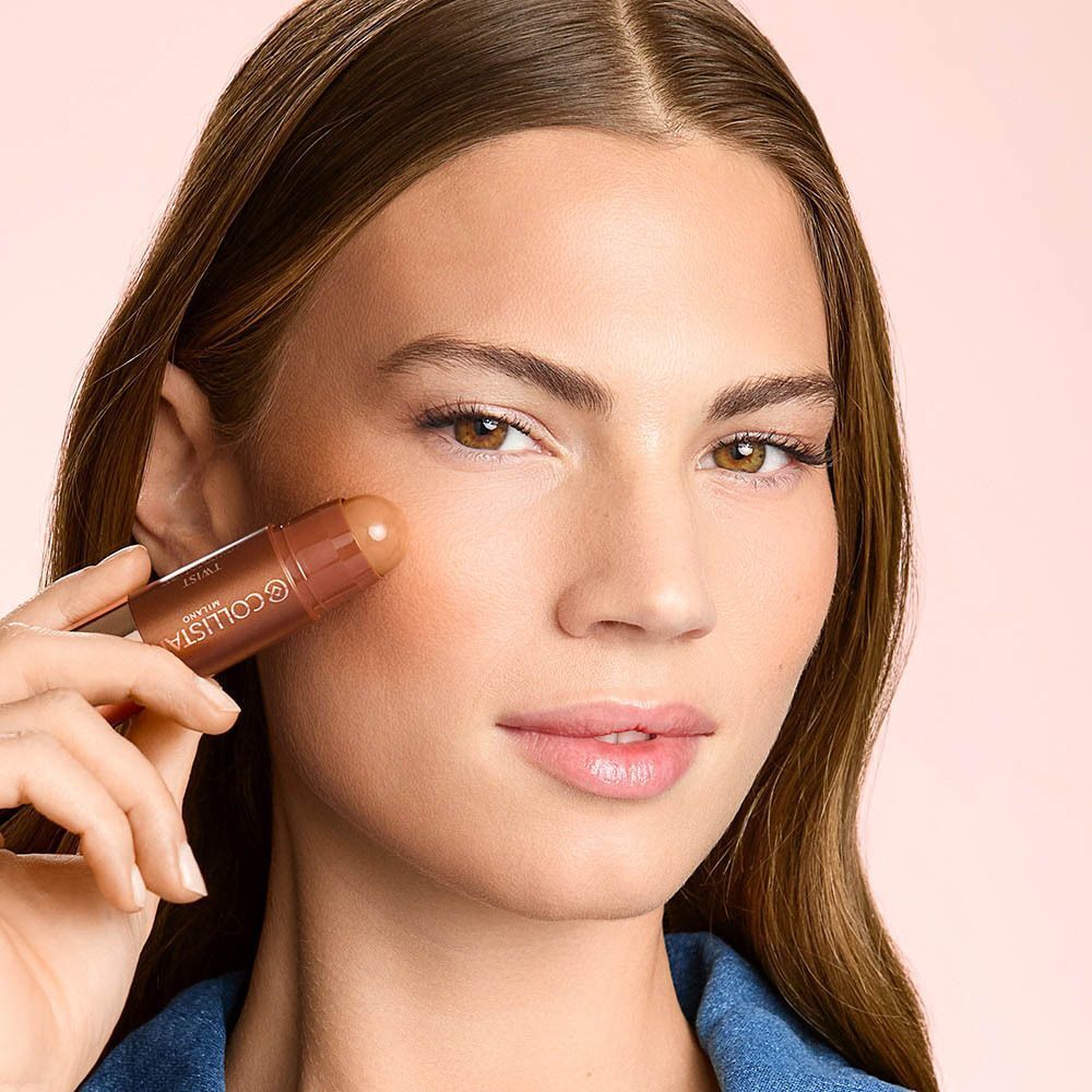 Une femme applique le Collistar Twist Velvet Bronzer avec le stick sur sa joue.