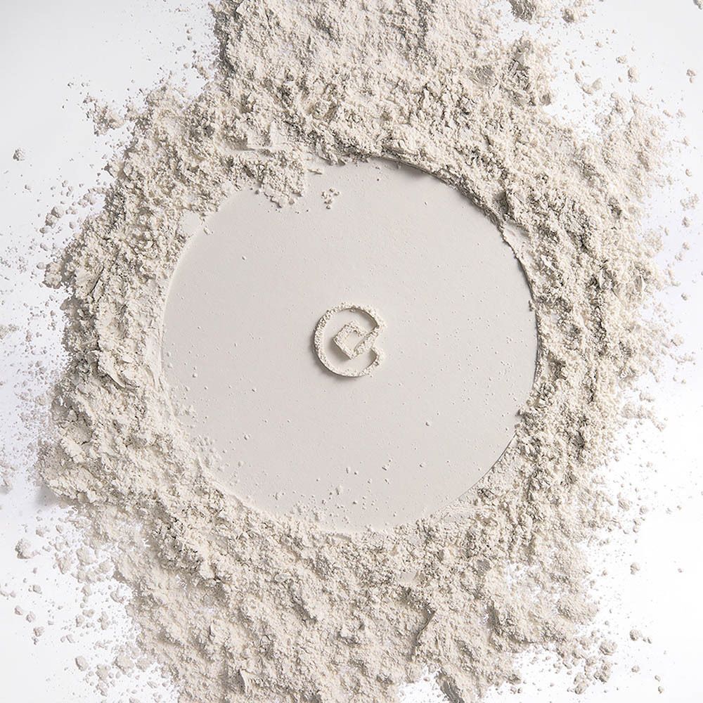 Poudre blanche éparpillée formant un motif circulaire avec un petit logo carré.