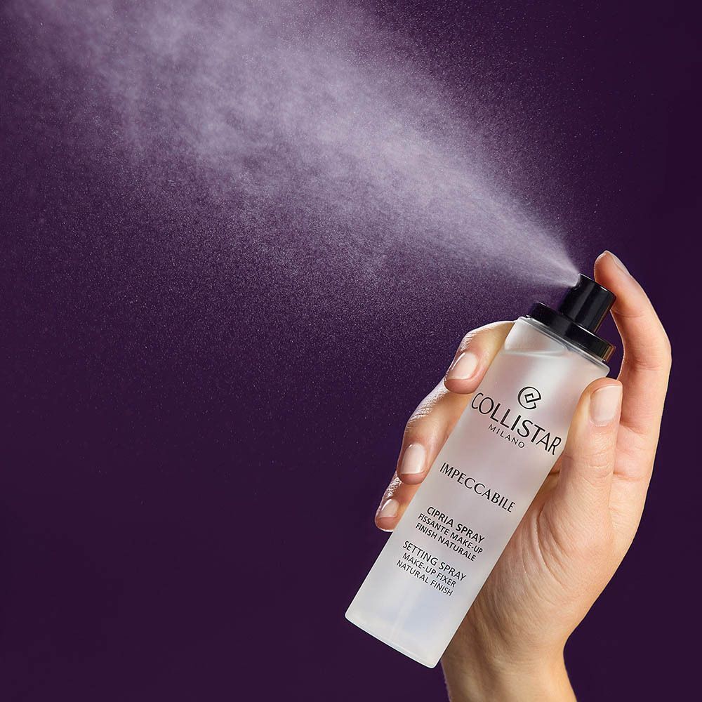 Hand houdt Collistar Impeccabile Setting Spray vast tijdens het sprayen.