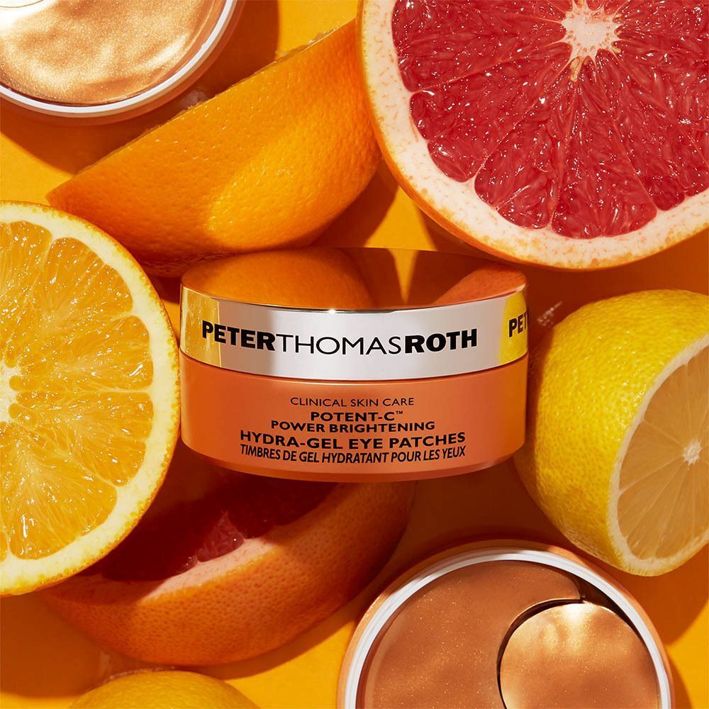 Een pot Peter Thomas Roth Potent-C oogpads omringd door citrusvruchten.