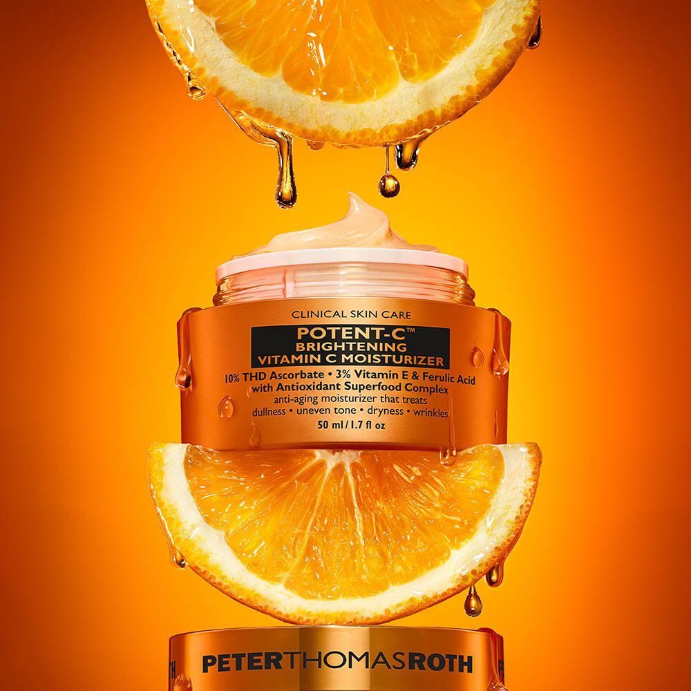 Peter Thomas Roth Potent C Brightening Vitamin C Moisturizer entre des tranches d'orange.