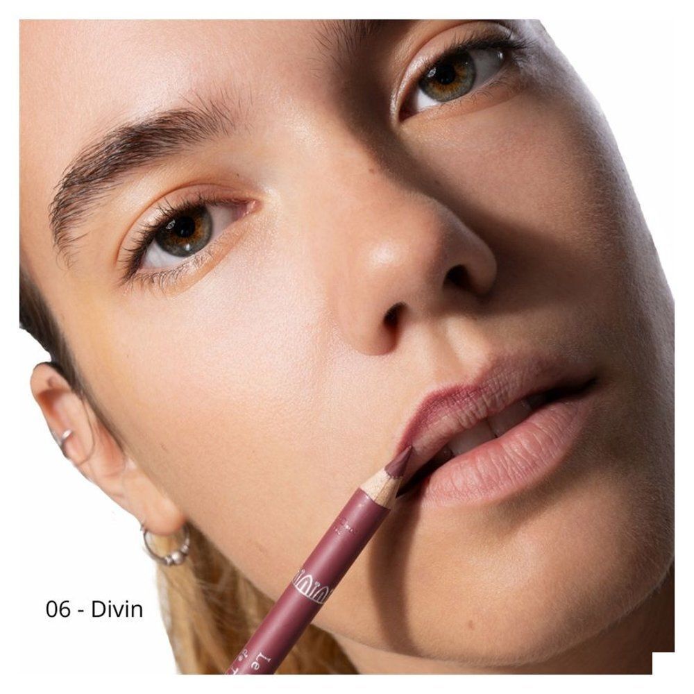 Een vrouw brengt een bordeauxrood lippenpotlood aan op haar lippen. Nummer 06 - Divin.