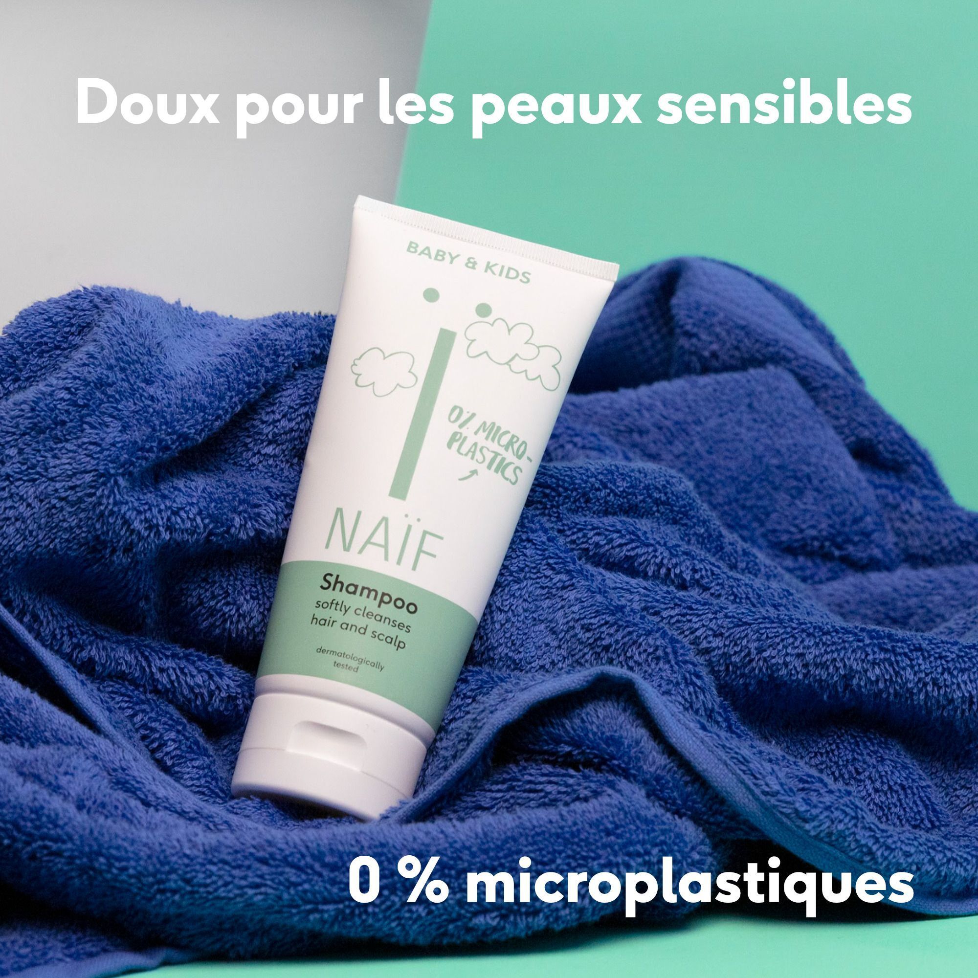 Bouteille de shampooing Naïf pour bébé sur une serviette bleue, 0% microplastique.