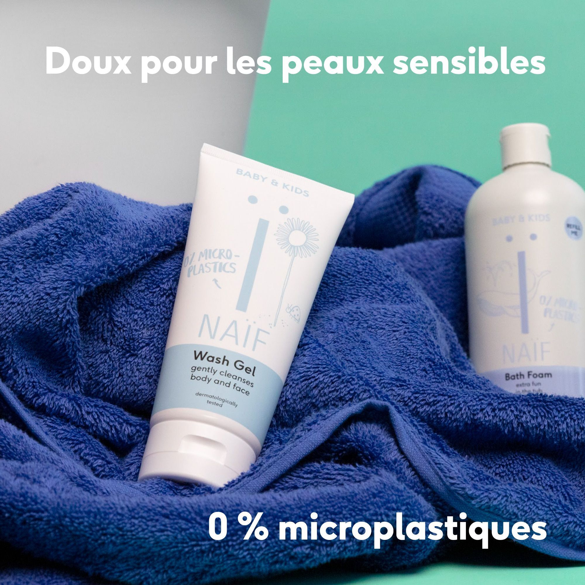 Un tube de Gel Lavant Naïf et une bouteille de Bain Moussant Naïf sur une serviette bleue.
