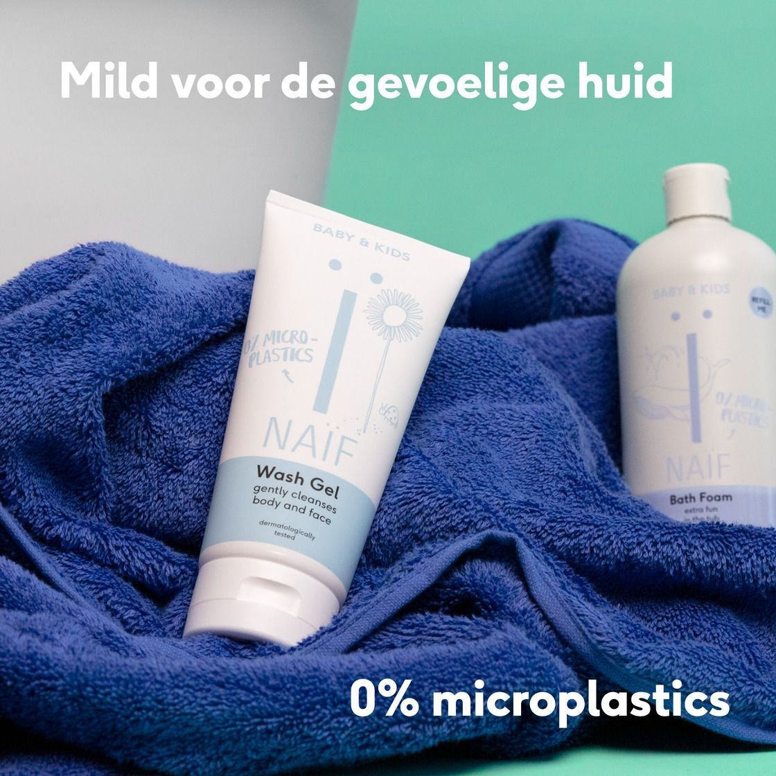Een tube Naïf Wasgel en een fles Naïf Badschuim op een blauwe handdoek.