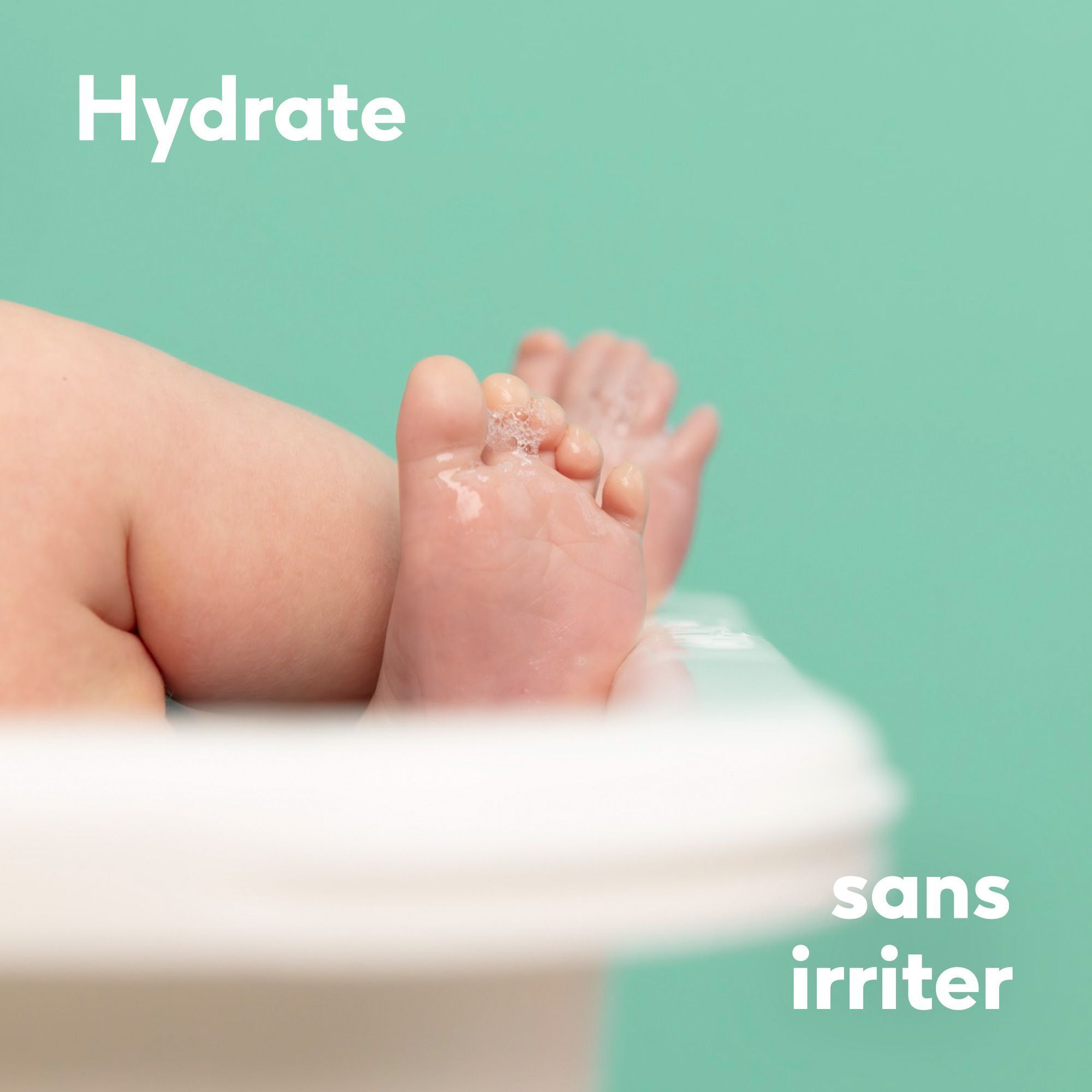 Pieds d'un bébé dans une baignoire avec des bulles d'eau.
