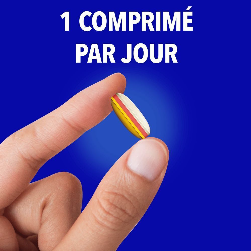 Une main tient une pilule tricolore entre le pouce et l'index.