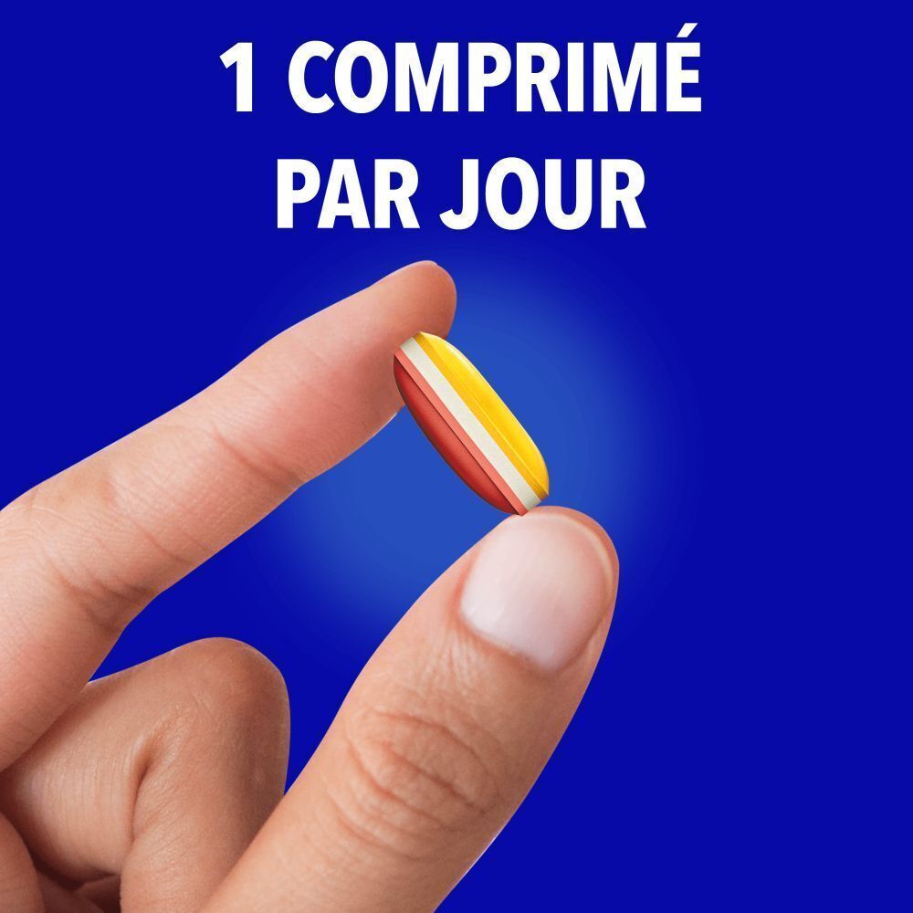 Une personne tient une capsule tricolore entre le pouce et l'index.
