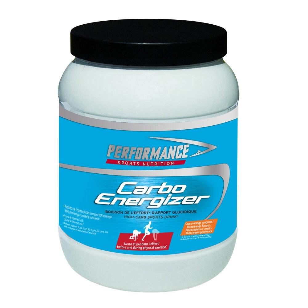 Pot blanc avec couvercle noir. Inscription: PERFORMANCE, Carbo Energizer. Bande bleue avec informations sur le produit.