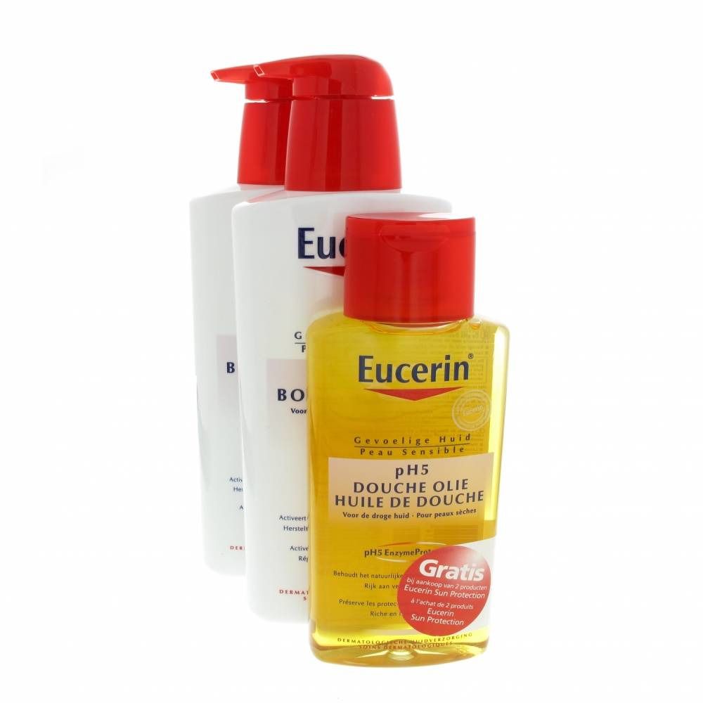 Drie producten voor lichaamsverzorging: twee witte flessen met rode pompen en een gele fles met rode dop. Opschrift: Eucerin.