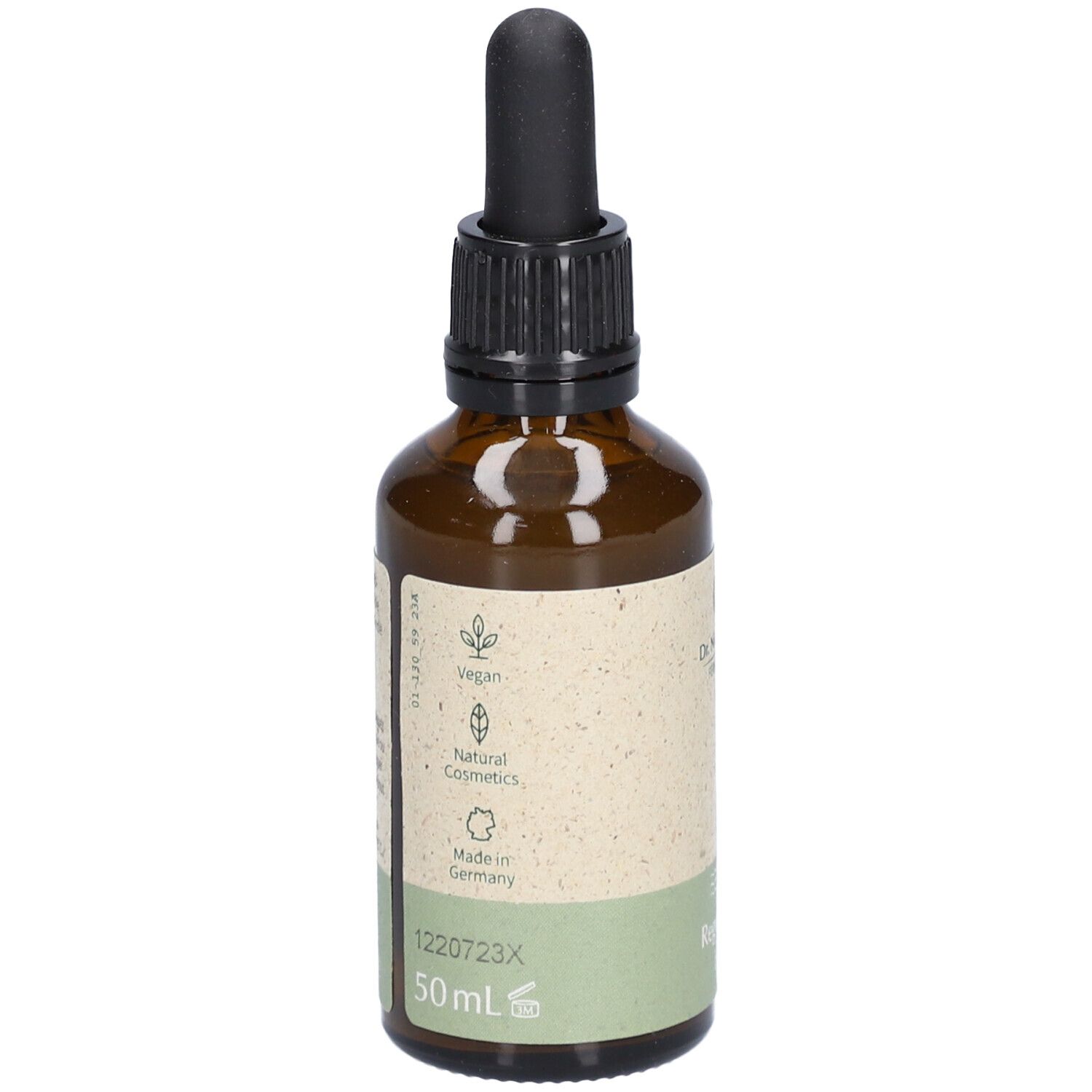 Achterkant van de bruine glazen fles. Etiket met informatie, Vegan-logo, Natural Cosmetics-logo en land van herkomst.