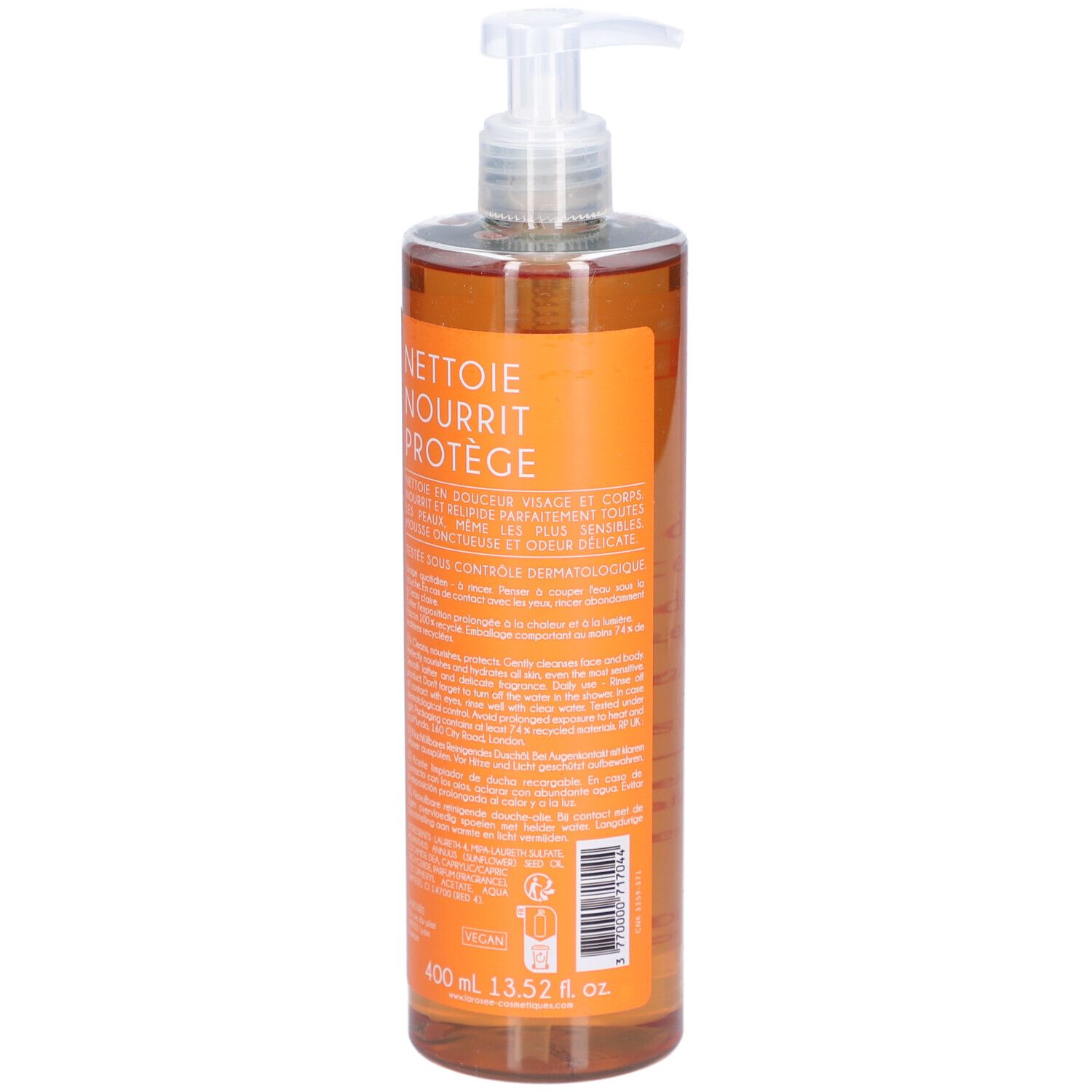 Achterkant van een transparante fles met oranje vloeistof. Tekst: Nettoie, Nourrit, Protège. 400 ml.