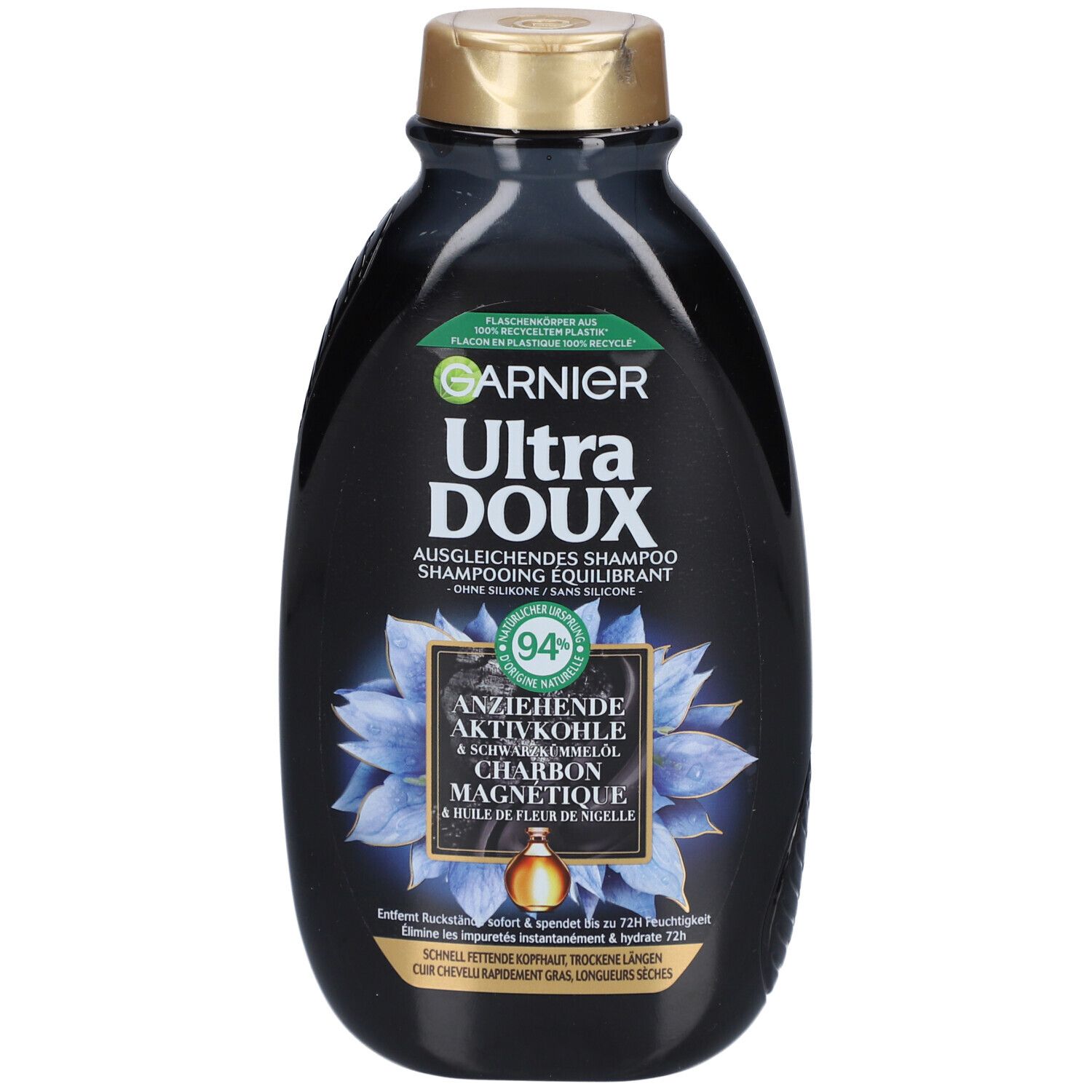 Zwarte shampoo fles, gouden dop. Tekst: GARNIER Ultra DOUX, Ausgleichendes Shampoo, Actieve kool & zwarte komijnolie. 94% ingrediënten van natuurlijke oorsprong.