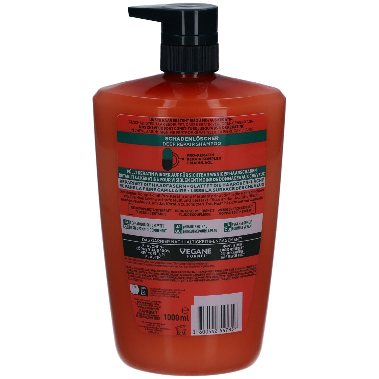 Achterkant van een oranje shampoo fles. Zwarte pomp. Tekst en logo's op etiket.