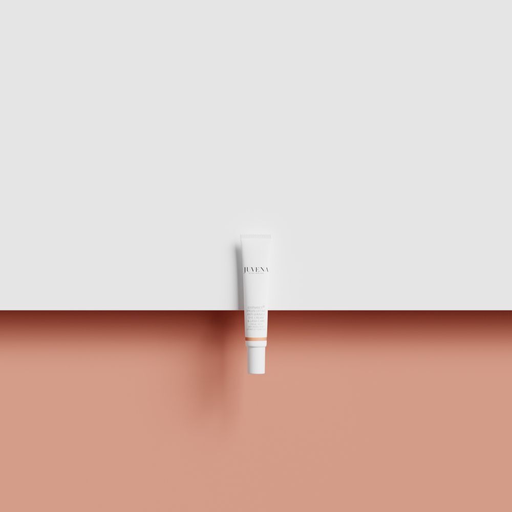 Witte tube op roze en witte achtergrond. Productnaam en merk niet zichtbaar.