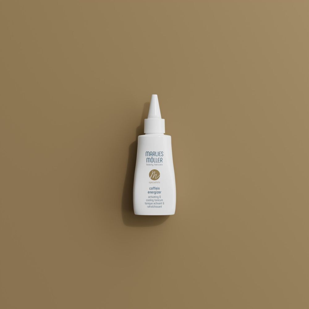 Witte fles met puntige applicator. Opschrift: Marlies Möller, Coffein Energizer. Op bruine achtergrond.