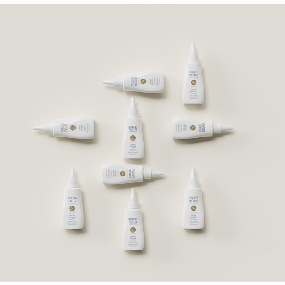 Meerdere witte flessen met puntige applicator, gerangschikt. Opschrift: Marlies Möller, Coffein Energizer.