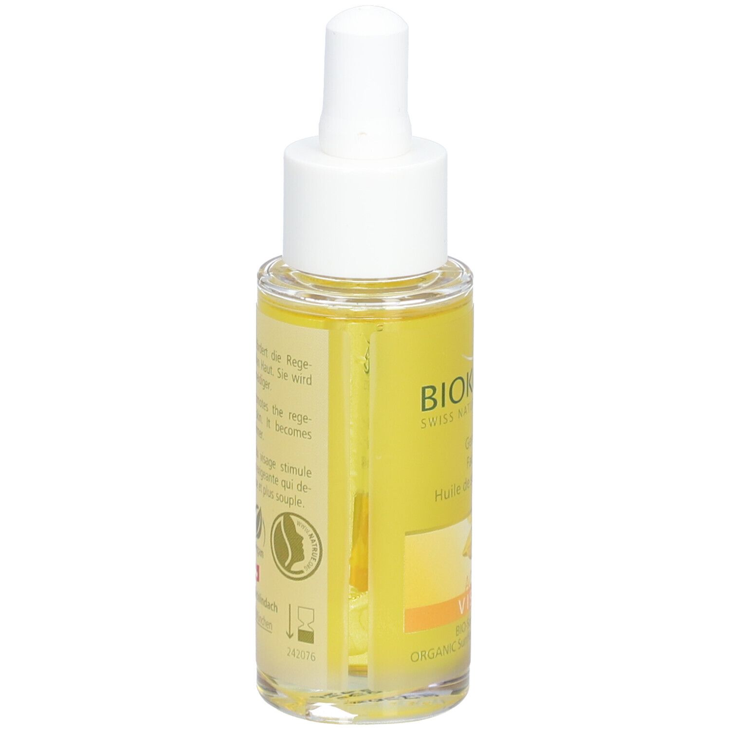 Gezichtsolie fles, achterkant. BIOKOSMA logo, tekst. Gele vloeistof zichtbaar. Vegan zegel. Zonnebloem illustratie.