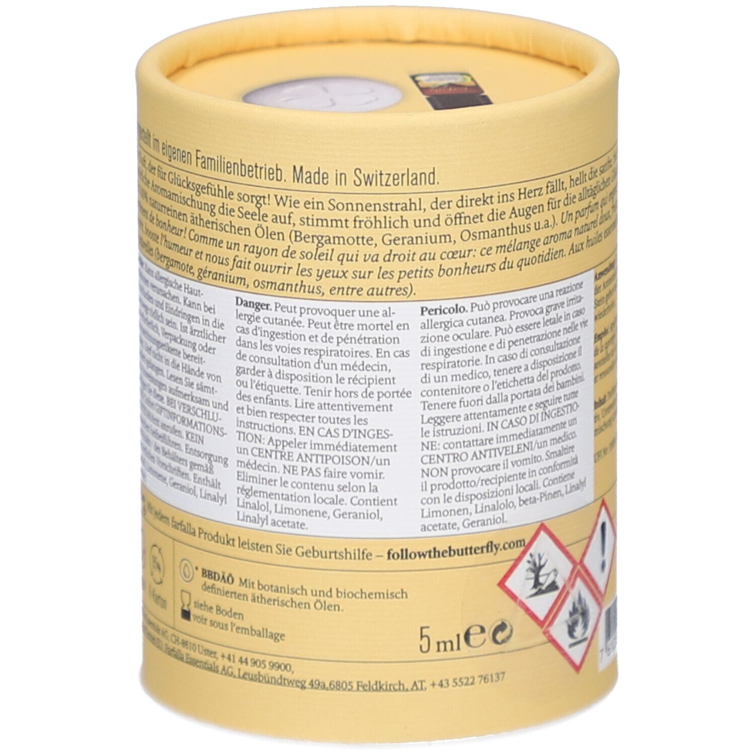 Achterkant cilindrische verpakking. Tekst over ingrediënten, gevarenwaarschuwingen. Botanische en biochemische etherische oliën. 5ml. Gevarensymbolen.