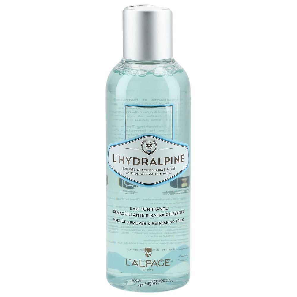 Transparante fles met zilveren dop. Etiket met productnaam L'Hydralpine en tekst. Blauwe vloeistof zichtbaar.