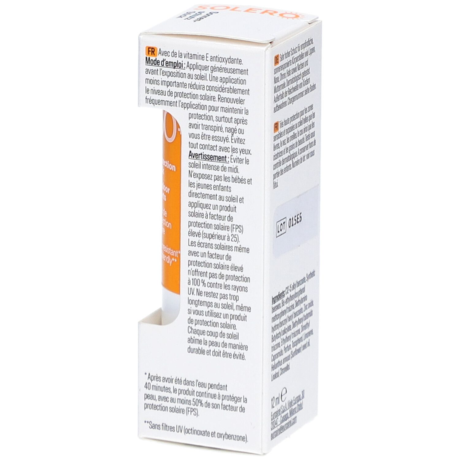 Verpakking van SOLERO zonnebrandstift. Bevat informatie over gebruik. Tekst: 12 ml. Lotnummer: 015E5. Oranje stick zichtbaar.