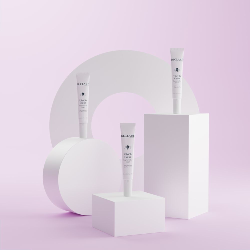 Drie tubes 'Olu'Olu Caviar Supreme Eye Cream op sokkels. Achtergrond met vormen. DECLARÉ-logo zichtbaar.