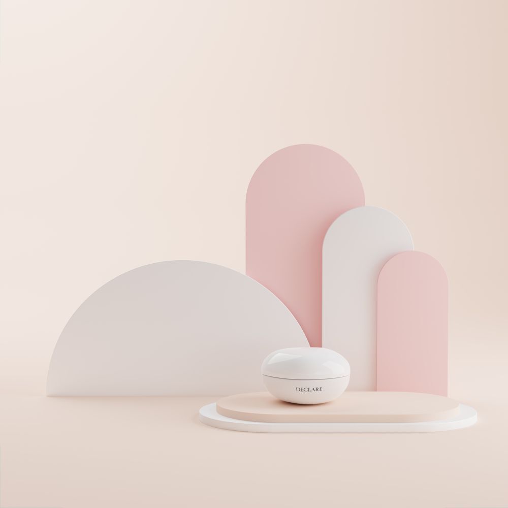 Witte pot op sokkel. Achtergrond: roze en witte vormen. Opschrift: DECLARÉ.