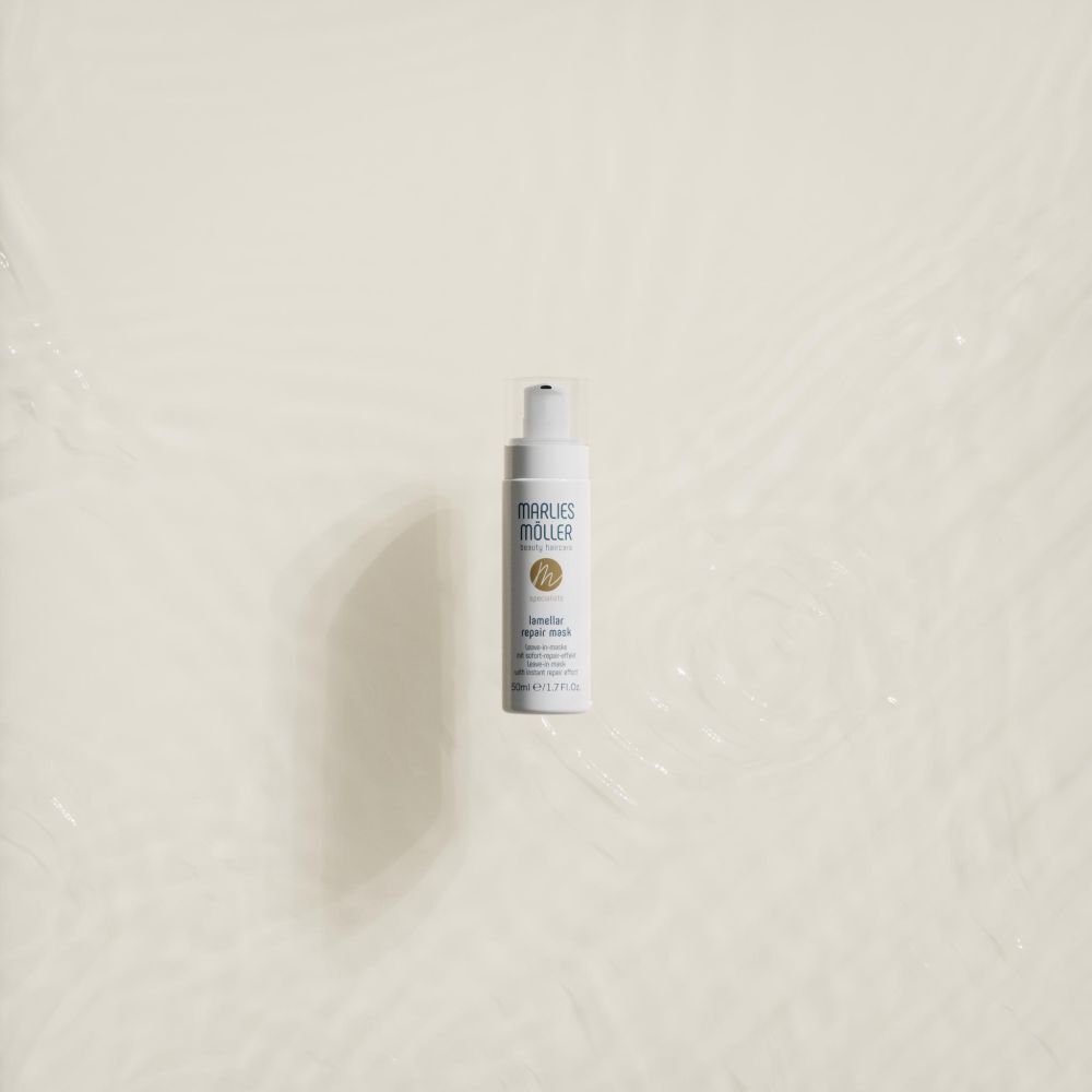 Witte fles met pomp in water. Opschrift: Marlies Möller, Lamellar Repair Mask. 50ml.