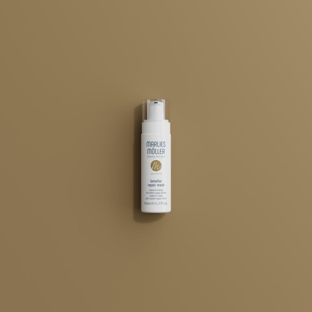 Witte fles met pomp op bruine achtergrond. Opschrift: Marlies Möller, Lamellar Repair Mask. 50ml.