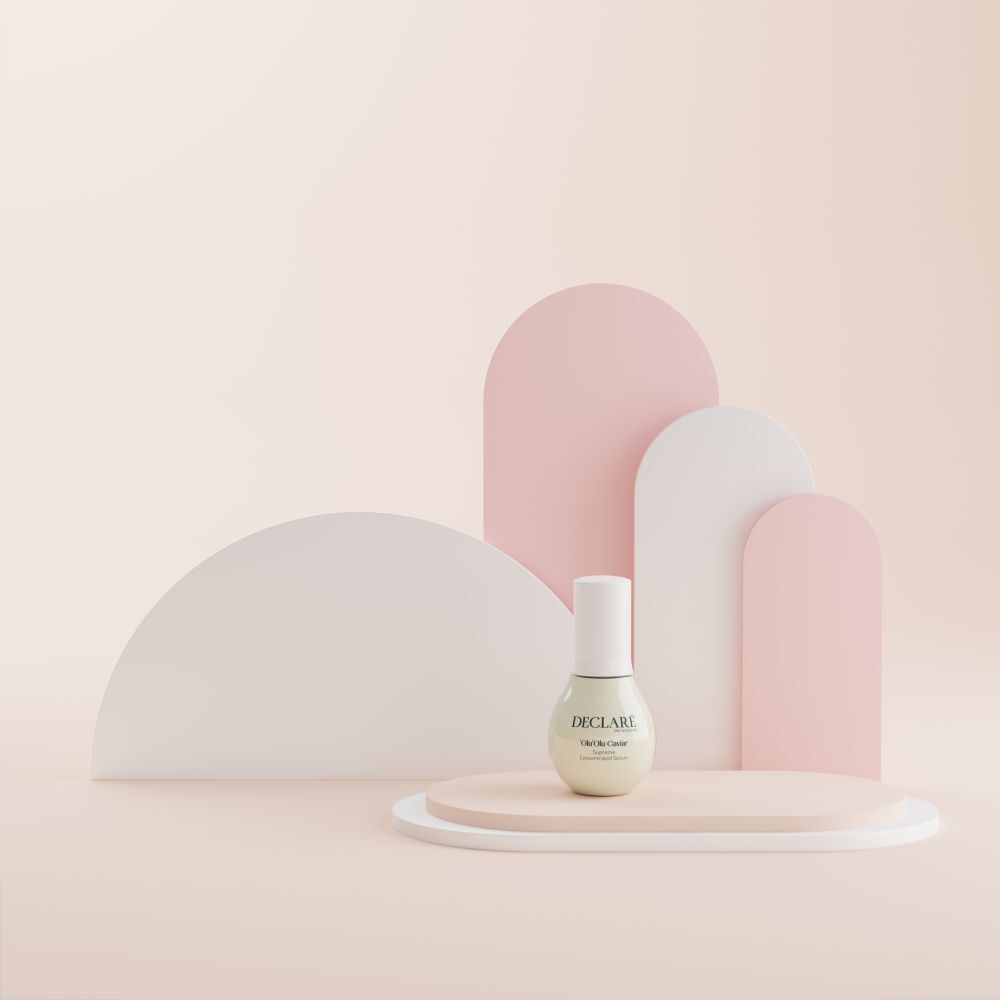 Flacon de sérum sur socle. Fond avec formes. Inscription: DECLARÉ, 'Olu 'Olu Caviar, Supreme.