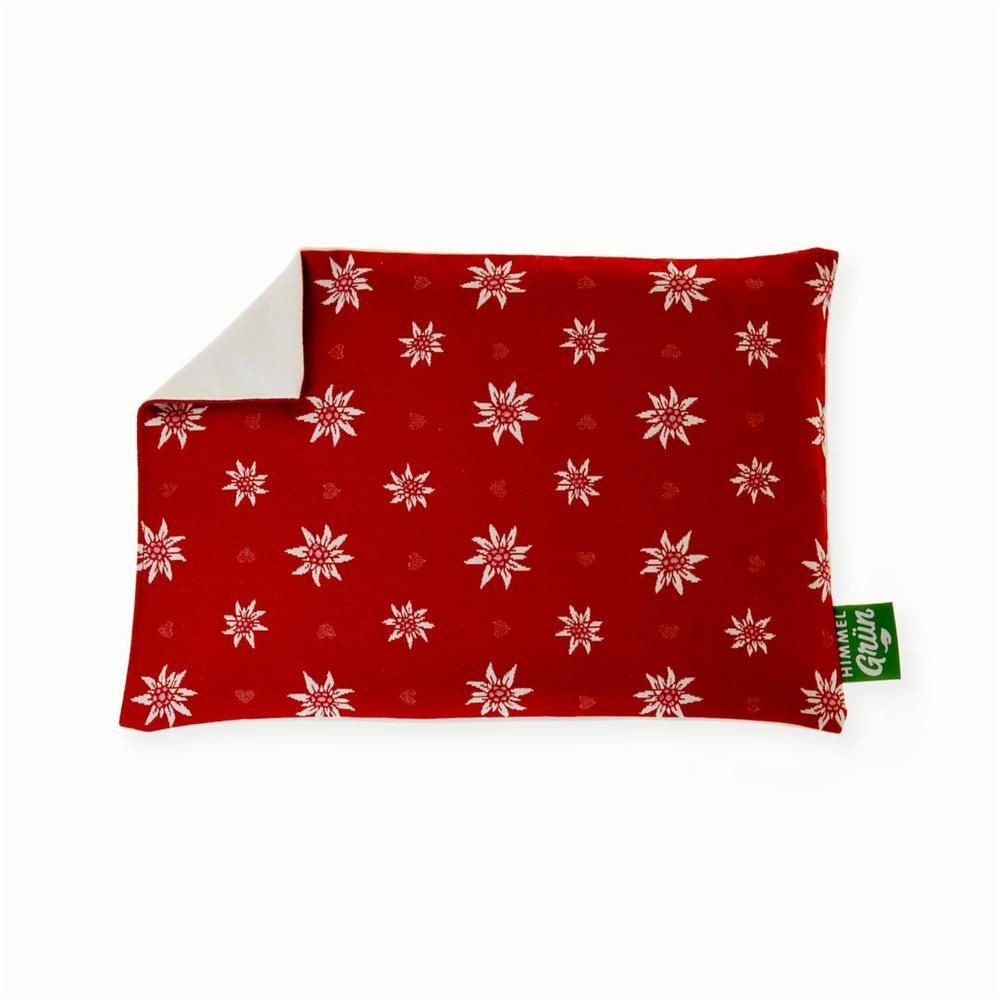 Coussin aux noyaux de cerises rouge avec motif edelweiss blanc et coeurs. Étiquette HIMMELGRÜN. Forme rectangulaire.