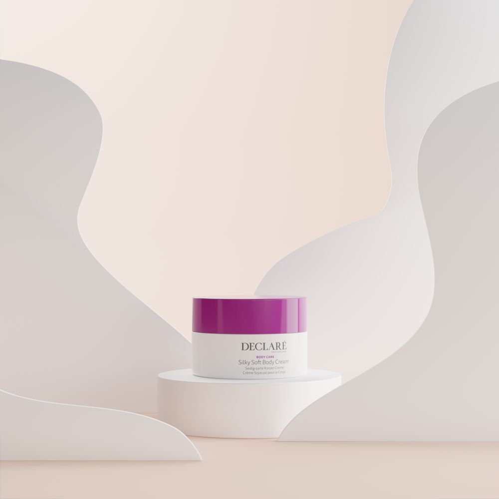 Witte pot met paarse deksel op wit voetstuk. Decoratieve, golvende elementen op de achtergrond. DECLARÉ-logo zichtbaar.