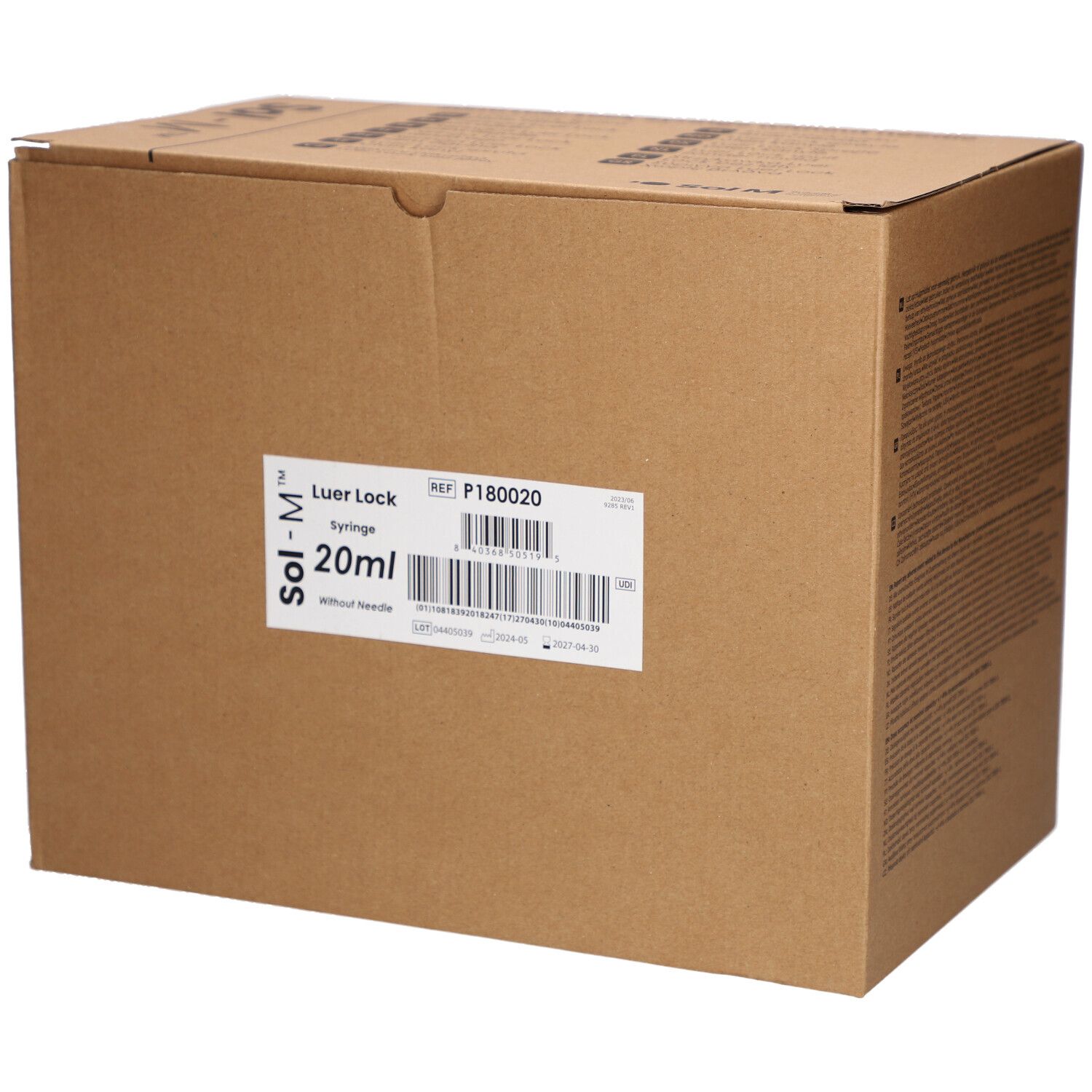 Boîte en carton avec étiquette. Inscription: Sol-M Luer Lock Seringue 20ml sans aiguille. Code-barres et référence.